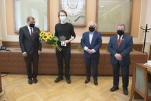 Zdjęcie wykonane w sali konferencyjnej. Na pierwszym planie stoją bok siebie, od lewej: Rektor AGH prof. Jerzy Lis, laureat Wojciech Daniło, prezes Fundacji dla AGH dr inż. Jerzy Kicki, prezes Stowarzyszenia Wychowanków AGH prof. Piotr Czaja. Usta i nosy s