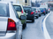 The photo shows several cars from behind, driving in a line on the road, and the cars are close to each other.
